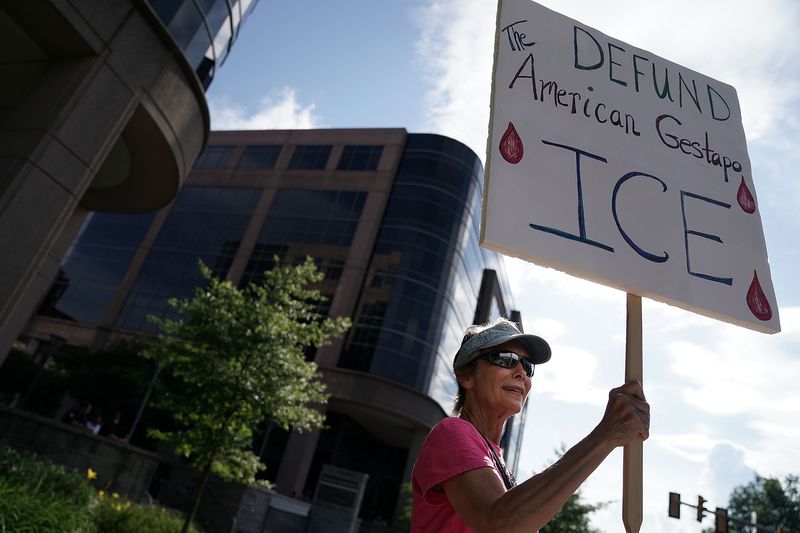 An activist holds a sign during a protest to abolish ICE.